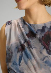 Vestido sin mangas con una tela translúcida que presenta un patrón floral abstracto en tonos azules, burdeos y malva. Diseño drapeado con una textura suave.