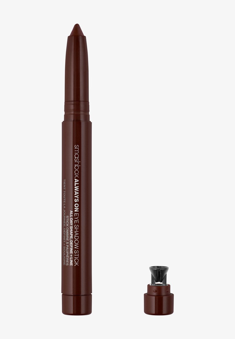 Brun øjenskygge stik med en spids spids og et aftageligt låg, der har brandingtekst i hvid. Glat, mat finish.