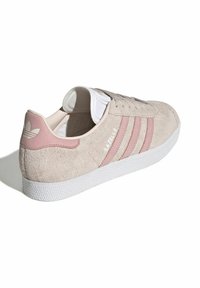 Beige zamšas kedas ar rozā ādas akcentiem un trim rozā svītrām. Baltā gumijas zole, teksturēta ārējā zole un mīkstināta mēle.