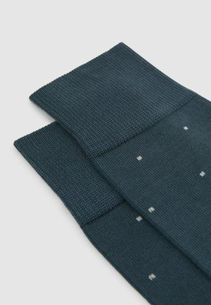 Material texturat de culoare albastru închis cu un model în grilă, având puncte mici albe. Două bucăți se suprapun cu margini drepte și linii curate.