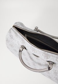 Sac à main gris à motifs avec fermeture éclair, anses doubles et un compartiment intérieur doublé d'un tissu de marque.