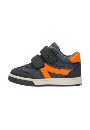 Baskets pour enfants en gris foncé avec des accents orange vif, deux bandes velcro noires et une semelle blanche.