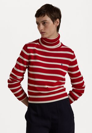 Pull à col roule rayé rouge et blanc avec des poignets et un ourlet côtelés. Présente un petit logo sur la poitrine. Fabriqué en matériau tricoté.