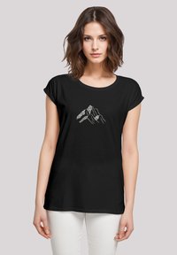 Zwarte t-shirt met korte opgerolde mouwen en een ronde halslijn. Heeft een zilveren bergafbeelding in het midden, op een gladde stof.