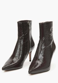 Czółenka za kostkę z wydłużonym noskiem, wykonane z błyszczącej ciemnoczerwonej lakierowanej skóry. Posiadają zamek błyskawiczny po boku oraz smukły obcas typu szpilka. Teksturowana powierzchnia.