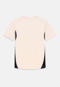 Kortärmad t-shirt i ljusbeige med svarta sidopaneler, med en slät textur och rundad nederkant. Minimalistisk design utan synliga logotyper.