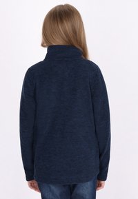 Granatowy polarowy sweter z wysokim kołnierzem i długimi rękawami, który charakteryzuje się teksturowanym, miękkim materiałem, gładkimi szwami oraz luźnym krojem.
