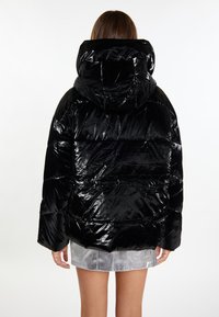 Schwarze Puffjacke mit einer glänzenden, gesteppten Außenseite und Kapuze. Das Design hat eine lockere Passform mit weiten Ärmeln und einem abgesetzten Muster.
