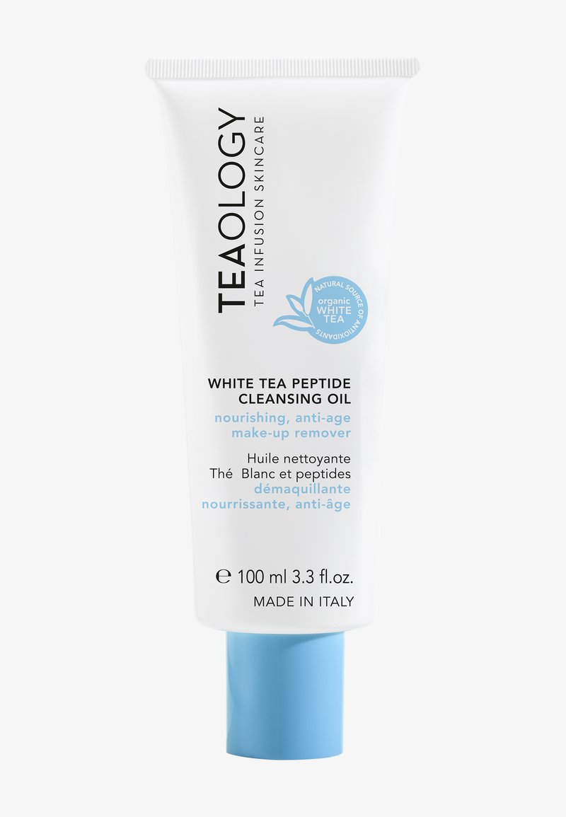 Tube blanche avec un capuchon bleu clair, étiquetée "Teaology Huile Nettoyante au Thé Blanc Peptidique," mettant en avant les propriétés nourrissantes et anti-âge.