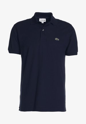 Polo blu navy in cotone con vestibilità classica, dotato di patta con due bottoni e un piccolo logo di coccodrillo verde sul petto.