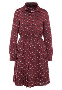 Abito rosso con maniche lunghe e chiusura con bottoni sul davanti. Presenta una vita cintrata e una gonna plissettata stampata con motivi circolari neri e rosa.