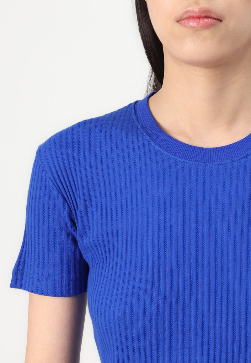 Niebieska prążkowana bluzka z krótkim rękawem i okrągłym dekoltem, wykonana z fakturowanej tkaniny, o dopasowanym kroju.
