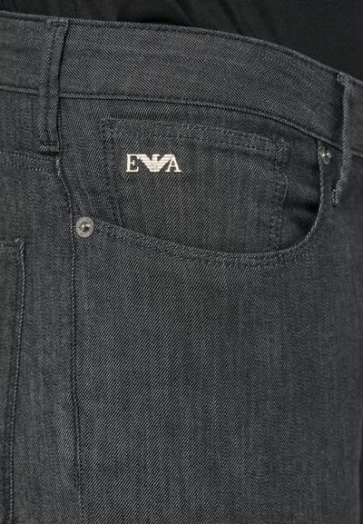 Črne džins hlače iz jeansa, ki imajo sprednji žep s srebrnim logotipom, trdno šivanje in običajen kroj. Gladek tekstura z rahlim sijajem.