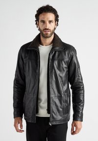 Schwarze Lederjacke mit einem braunen Schafsfellkragen, Reißverschluss und seitlichen Taschen. Sie zeichnet sich durch eine glatte Textur und eine taillierte Passform aus.