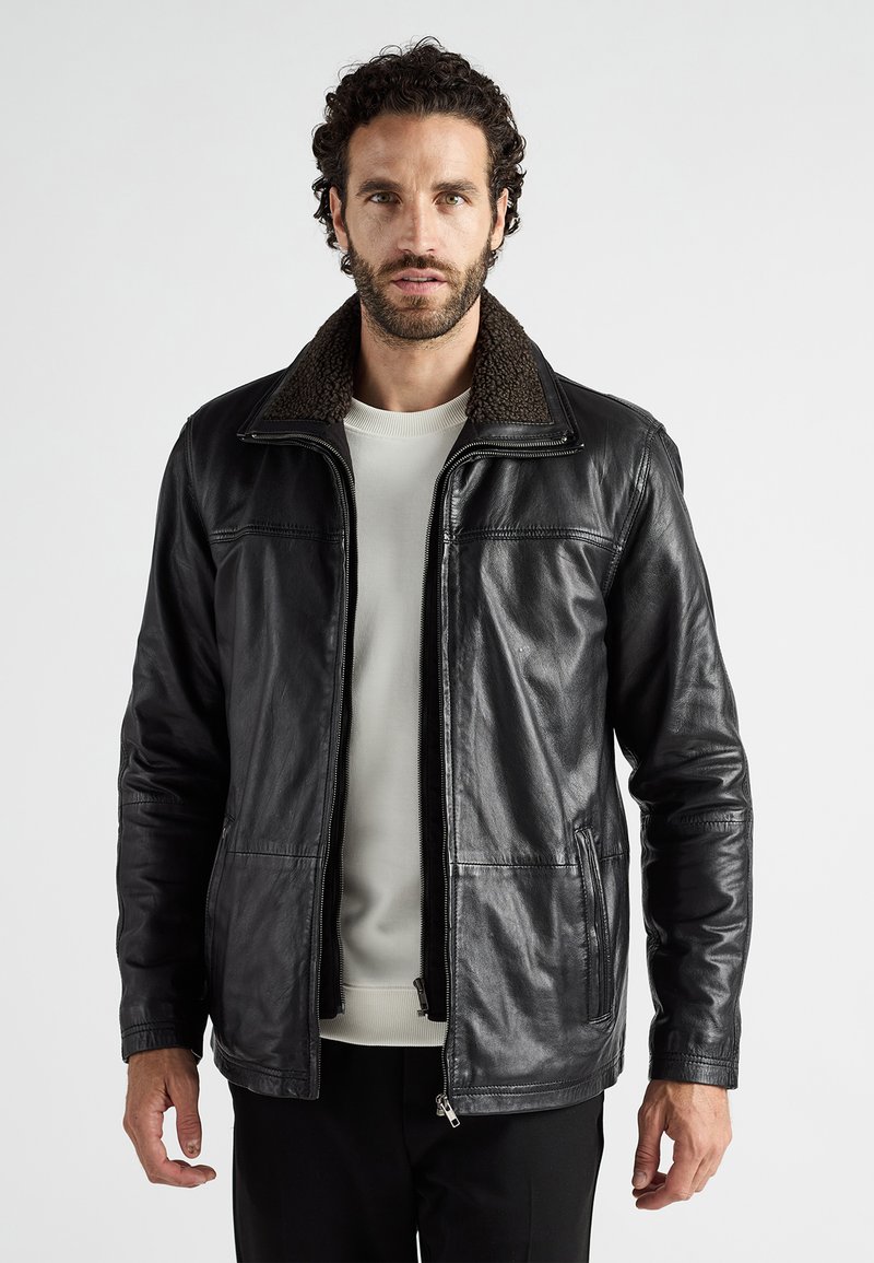 Schwarze Lederjacke mit einem braunen Schafsfellkragen, Reißverschluss und seitlichen Taschen. Sie zeichnet sich durch eine glatte Textur und eine taillierte Passform aus.