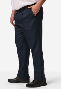 Námořnické modré kalhoty s hladkou texturou, sklady na přední straně, bočními kapsami a jemným tkaným vzorem, spojené s černými společenskými botami.