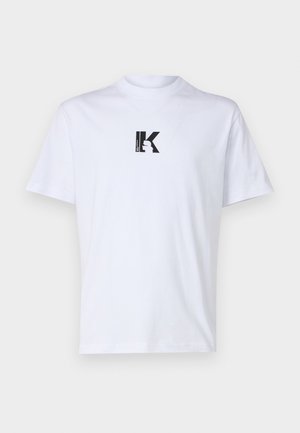 Λευκό βαμβακερό T-shirt με μαύρη γραφική εκτύπωση που απεικονίζει το γράμμα "K" σε τετράγωνο σχέδιο. Κλασικό στρόγγυλο λαιμό και κοντά μανίκια.