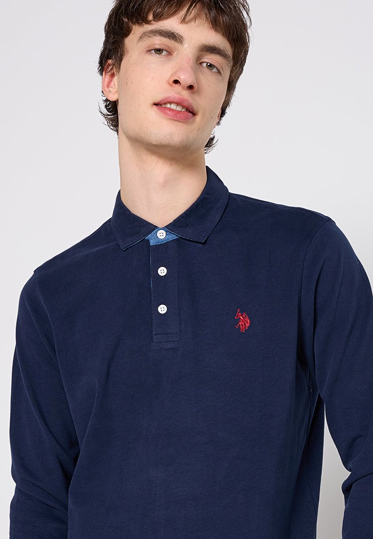Navyfarbener Langarm-Polo-Shirt aus Baumwolle in einfarbig, mit einem kontrastierenden blauen Kragen und einem kleinen roten gestickten Logo auf der Brust.