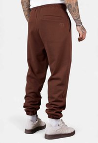 Braune Sweatpants aus weichem Stoff, mit schmal zulaufendem Bein, elastischem Bund und einer Gesäßtasche mit Logodetail.