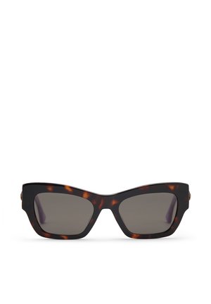 Okulary przeciwsłoneczne w oprawie typu „cat-eye” o szerokim kształcie, z ciemnoszarymi szkłami oraz złotymi akcentami na zausznikach. Wykonane z gładkiego plastiku.