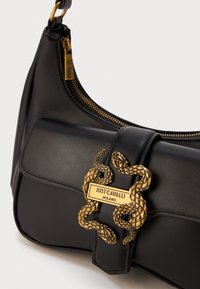 Black leather handbag with gold zipper and ornate gold snake clasp featuring "Just Cavalli Milano" plaque.