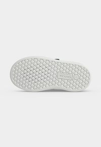 Semelle de chaussure blanche avec un logo de marque Geox rectangulaire, une semelle à motif en losange et de petits trous d'aération ronds sur un fond uni.