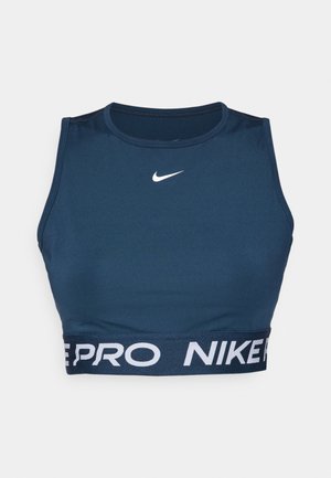 Navy športová podprsenka vyrobená z elastického materiálu. Má okrúhly výstrih a kontrastný biely pás s logom "NIKE PRO" na spodnej strane. Hladká štruktúra.