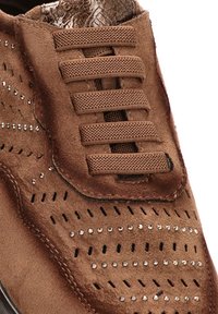Zapato de ante marrón con perforaciones decorativas, acentos de cristal y cordones planos. La textura es suave con un acabado liso.