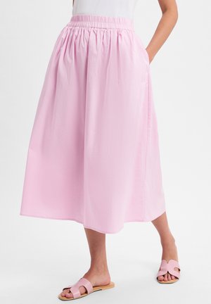 Light pink maxi skirt with an elastic waistband, featuring side pockets and a flowing, smooth texture. Worn with matching pink sandals.