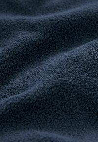 Marineblåt fleece-stof med en blød, struktureret overflade og subtil dybde, der har et glat, sammenhængende fald uden synlige mønstre eller accenter.