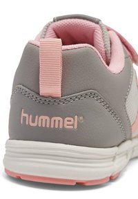 Graue Sneakers mit pinken Akzenten, Obermaterial aus strukturiertem Leder und Mesh, gepolsterter Kragen, flexible weiße Sohle und genähte Details. Markenlogo vorhanden.
