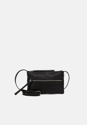 Svart läderväska med axelrem, har en dragkedjeficka framtill, justerbar rem, slät yta och minimalistisk design.