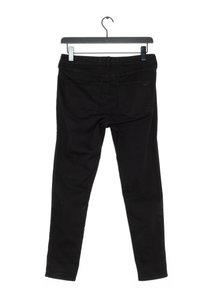 Svart denimjeans hängde på en svart galge, visad från baksidan med synliga fickor och bältesöglor.