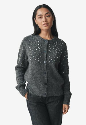 Gray cardigan made of textured knit fabric. Features pearl embellishments on the shoulders and buttons down the front. Long sleeves.