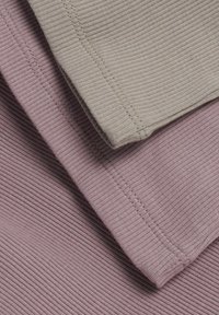 Drei gerippte Stoffproben in gedeckten Farben: hellgrau, blassrosa und mauve. Jede hat eine glatte Textur und sichtbare Nahtdetails.