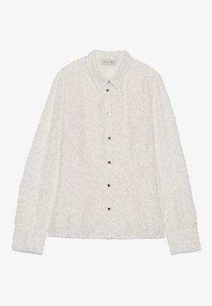 White button-up shirt with textured fabric, diamond pattern, and a pointed collar. Features silver buttons and long sleeves with cuffs.