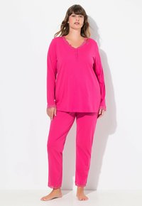 Rosa langärmliges Pyjama-Set mit einem V-Ausschnitt und Bündchen aus Spitzenbesatz, dazu passende Hosen mit Spitzenakzenten am Saum.
