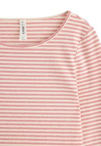T-shirt i bomuld med scoop-udskæring og korte ærmer. Stoffet er cremefarvet med tynde røde striber, der løber vandret.