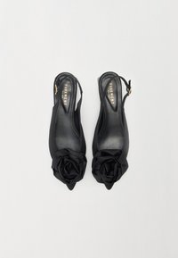 Črne slingback čevlje z izostrenim nosom, ki imajo na sprednjem delu satensko cvetno dekoracijo in gladko, sijočo notranjost. Zlati detajli.