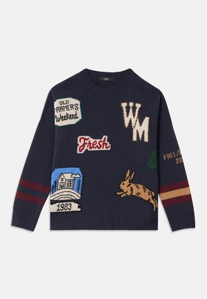 Navy sweater featuring knit patches with various designs, including a rabbit, a house with trees, and text elements in contrasting colors.