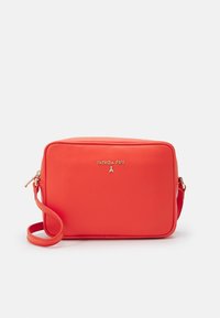 Rød håndtaske med tekstur og rektangulær form, prydet med et gyldent logo, lynlås øverst og justerbar skulderrem.