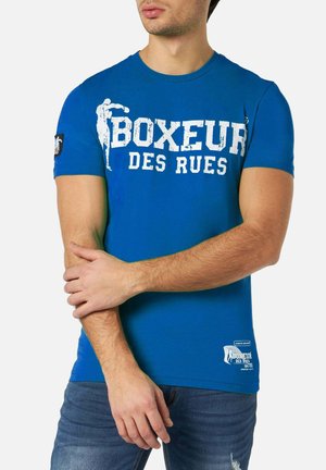 T-shirt in cotone blu con stampa grafica bianca che riporta la scritta "BOXEUR DES RUES" e un logo applicato sulla manica. Maniche corte, scollatura tonda.