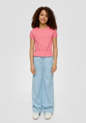 Roze top met korte mouwen en een geraffineerde taille, gecombineerd met lichtblauwe wijde broek en witte sneakers. Soepele stof en een relaxte pasvorm.