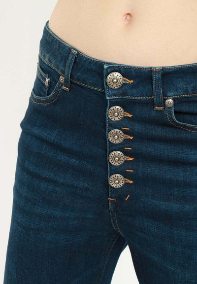 Jeans in denim blu scuro con design a vita alta, dotati di sei bottoni metallici decorativi, cuciture arancioni a contrasto e una tasca frontale.