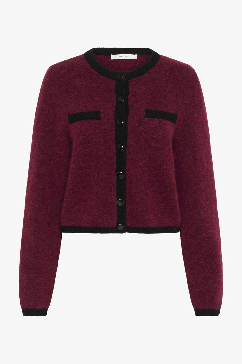 Bordový vlnený kardigán s čiernymi detailami, s okrúhlym výstrihom, predným zapínaním na gombíky a dvoma náprsními vreckami. Štruktúrovaný povrch.