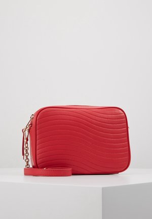 Rød rektangulær crossbodytaske med bølget sømmønster, guldkæde som remdetalje og matchende rød læderrem til håndleddet.