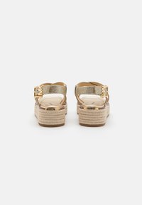 Gold glitter espadrille sandals with adjustable ankle strap and tan braided platform. Features metallic hardware and cushioned footbed.