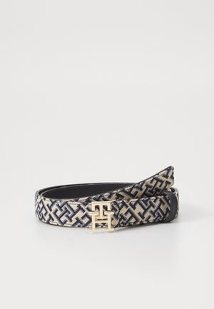 Ceinture en tissu avec motif géométrique noir et beige, avec une boucle dorée en forme des lettres entrelacées "T" et "H".