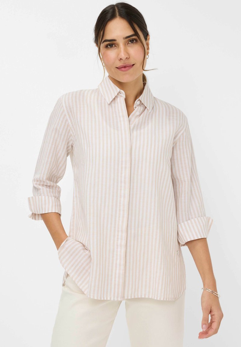 Light pink and white striped button-up shirt with long sleeves rolled up. Features a collared neckline and side pockets. Smooth fabric texture.