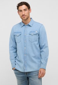 Jasnoniebieska koszula dżinsowa z kołnierzykiem zapinanym na guziki, dwiema kieszeniami na piersi oraz długimi rękawami z zapięciem na guziki. Gładka tekstura, casualowy design.